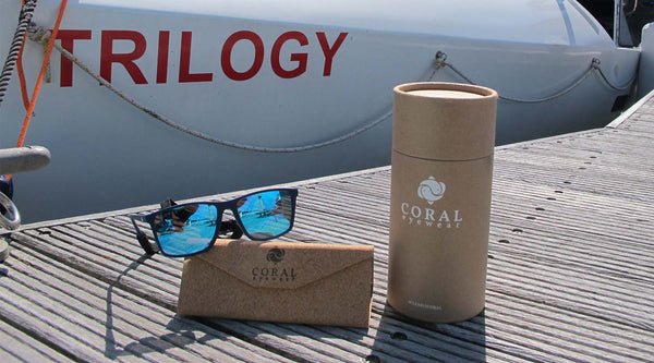 Polarised sunglasses in front of white rowing boat