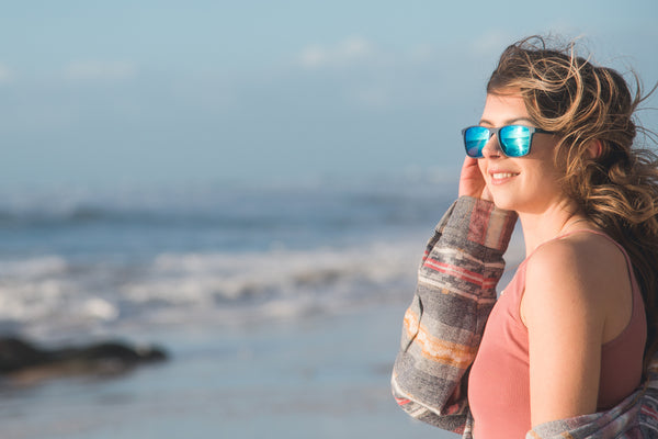Female surfer wearing polarised sunglasses on Newquay beach